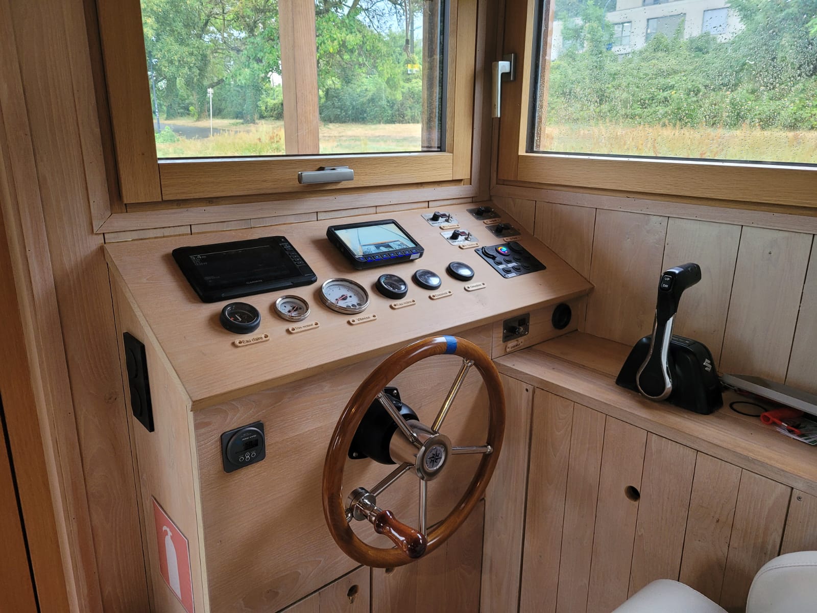 Poste de pilotage du bateau avec barre en bois et instruments de navigation